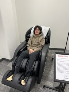 Syracuse University student enjoying Barnes Center at The Arch Mindspa massage chair.