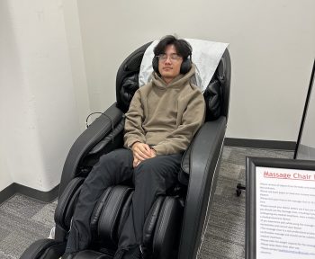 Syracuse University student enjoying Barnes Center at The Arch Mindspa massage chair.