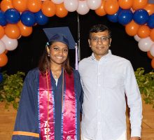 A student and her guest post for a photo at the graduation reception