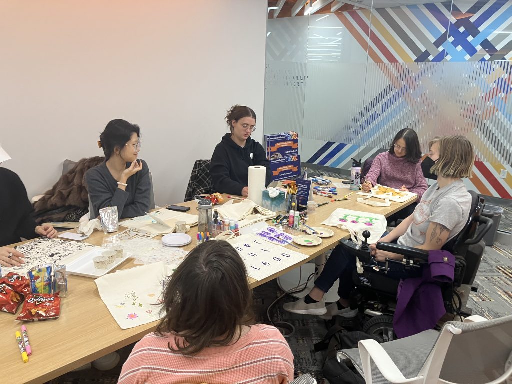 Students together at a table working on arts and crafts.