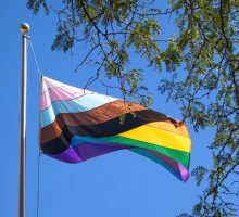 A Pride Flag flies on the quad in the summertime.