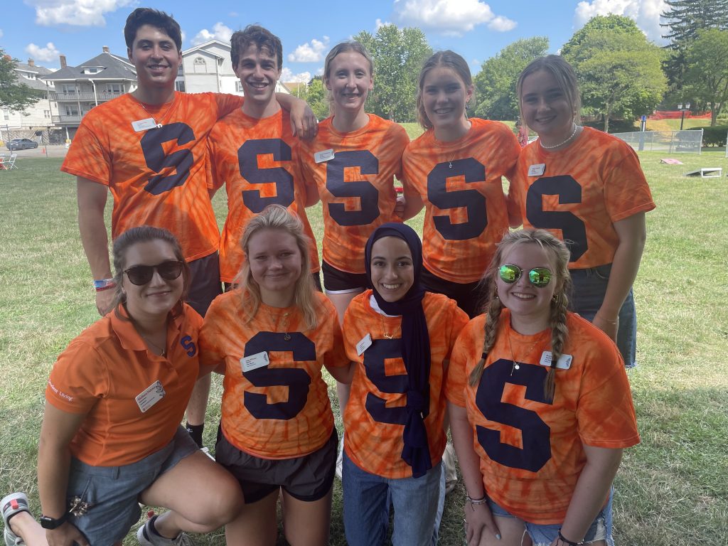 2022-2023 peer mentors pose for a group photo wearing orange tie-dye shirts with Syracuse's Block S logo