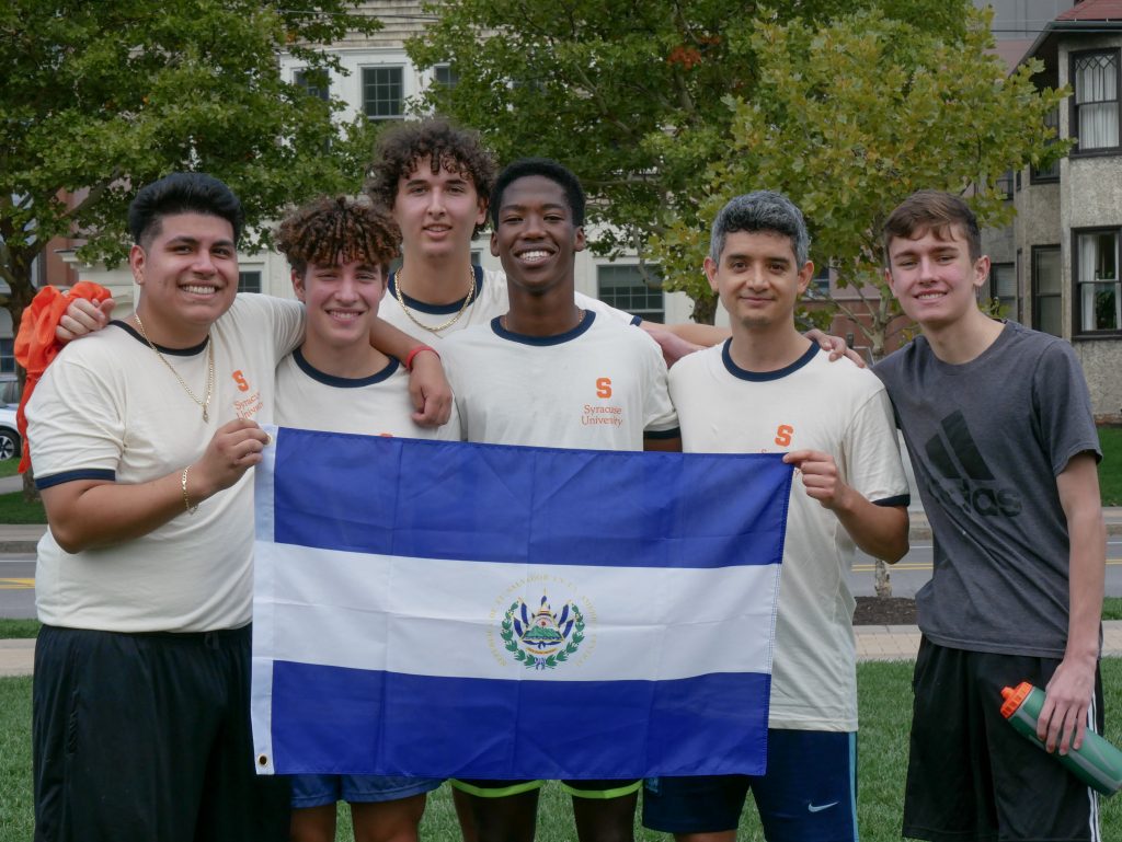 Smiling students hold the flag of El Salvador 