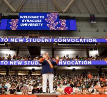 Syracuse University New Student Convocation band director leading music.