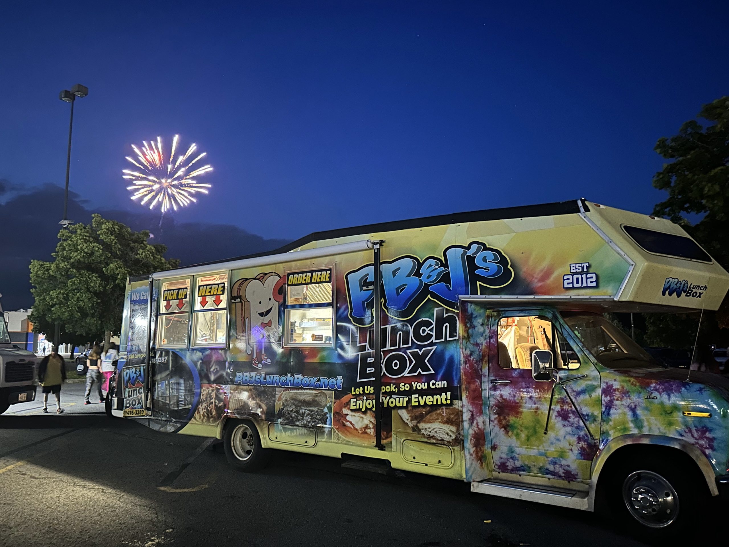 PB&J's lunchbox food truck at night with fireworks in the background
