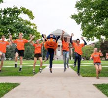 Students jumping with Otto on the Quad.