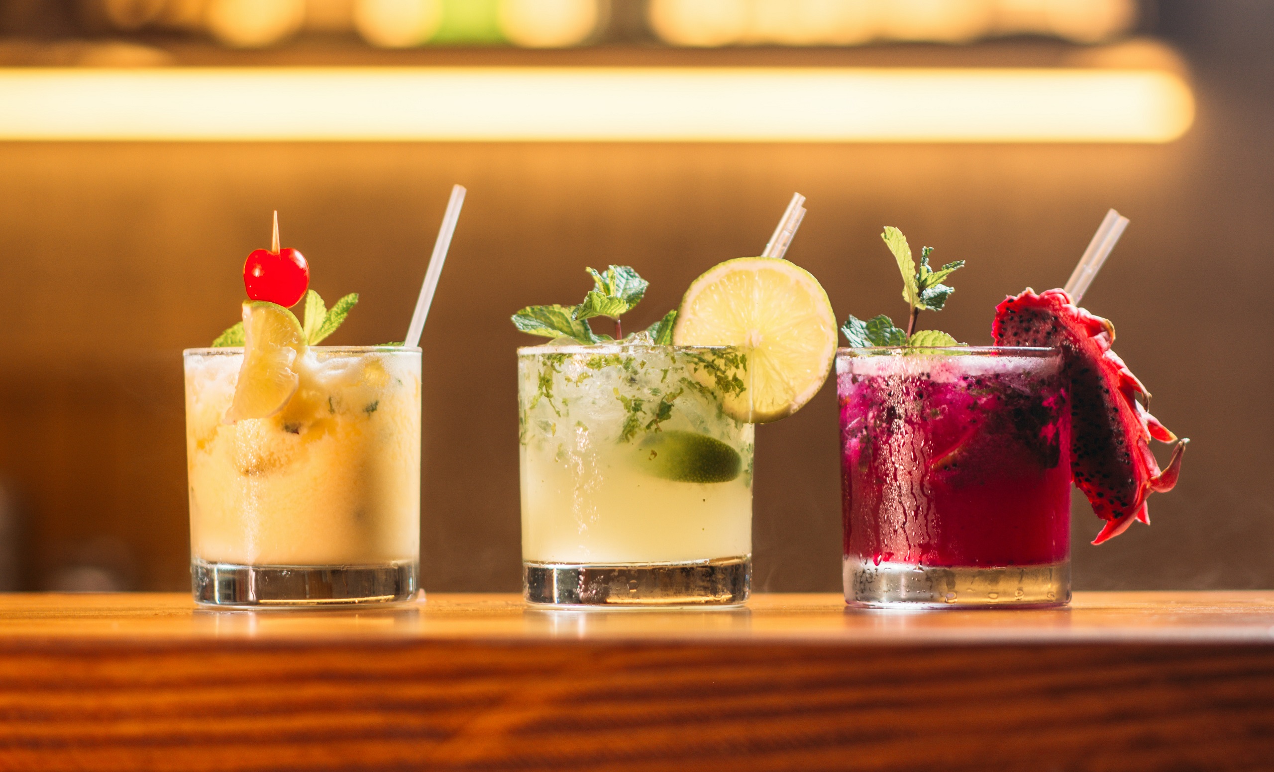 Three fancy drinks sit on a table ledge