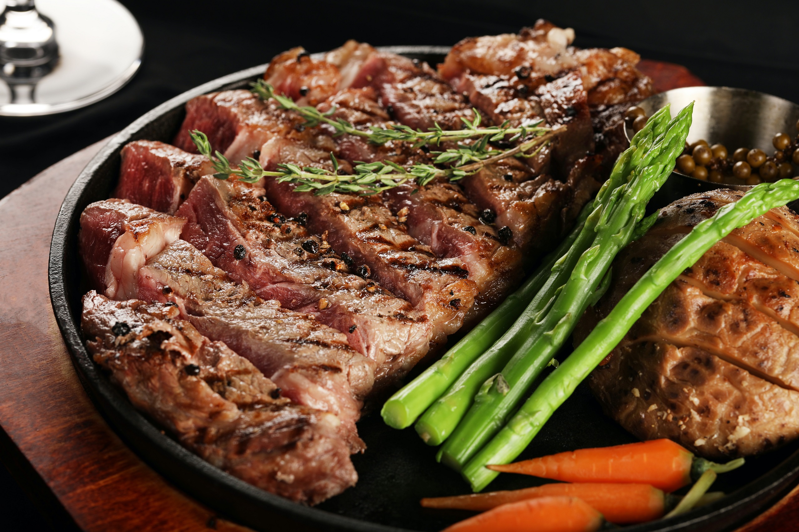 Steak and asparagus on a black plate