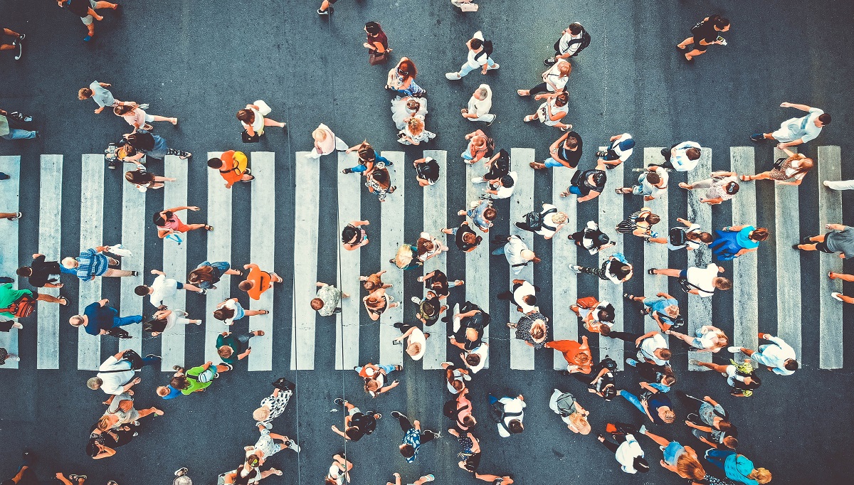 A crowd of people using a crosswalk.