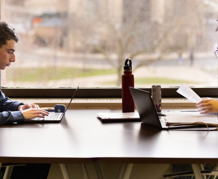 Two students studying at a table in the library.