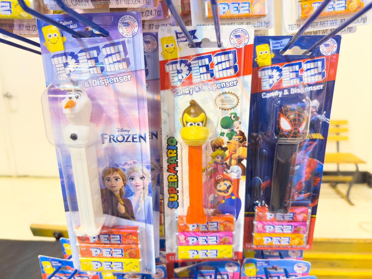 Packages of PEZ dispensers hanging on a rack at a store.