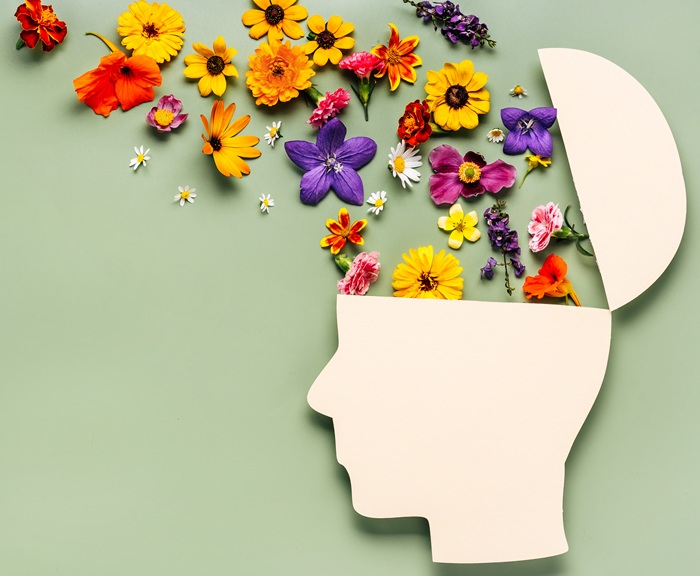 Art of a paper human head with flowers pouring into their brain