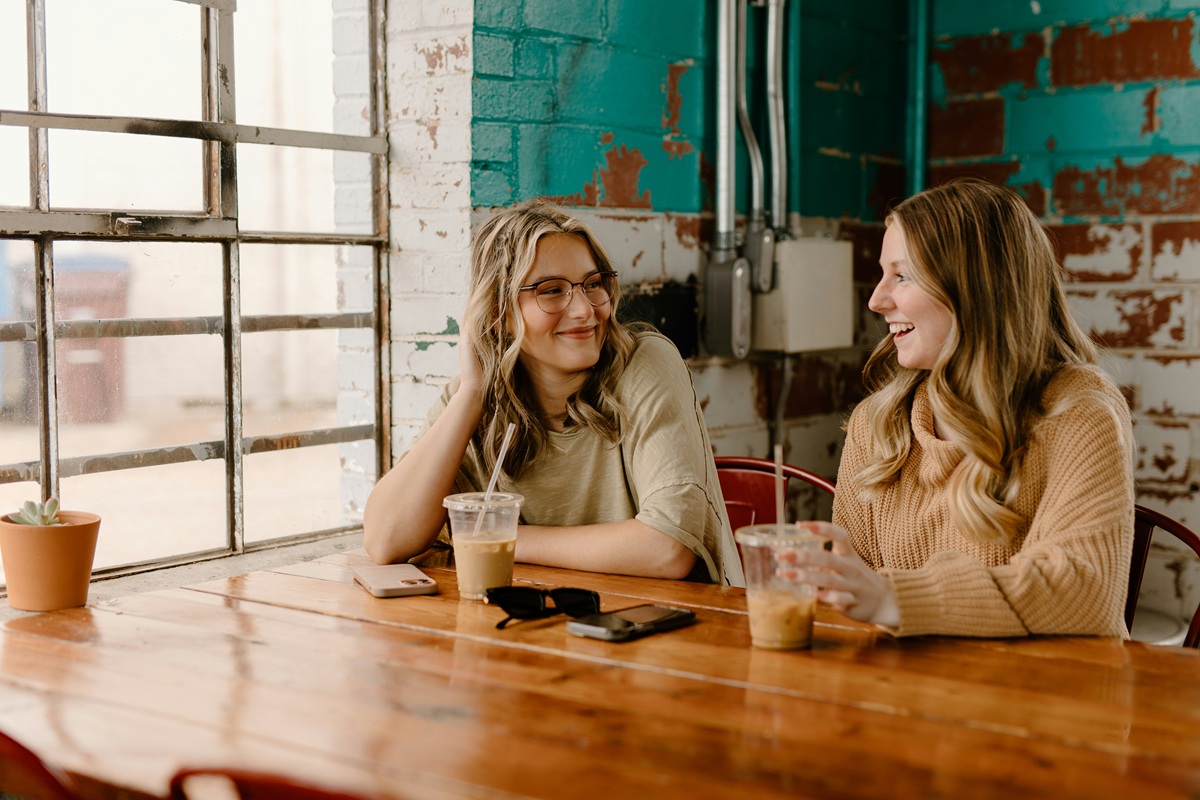 Two women have coffee together at a cafe.