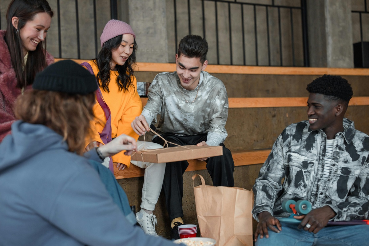 A group of people hand out takeout food to each other.