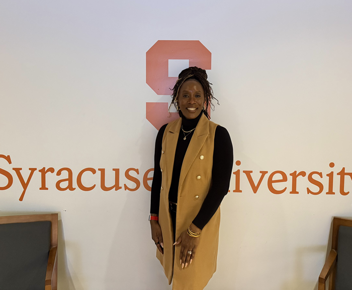 Dean Dixon standing in front of a sign that says Syracuse University