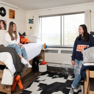 Two students pose in their residence hall room.