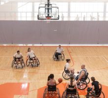 Individuals participate in an accessible basketball game.