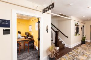 Interior shot of the Barner-McDuffie House's first floor hallway, including the reception area, staircase, and some artwork.